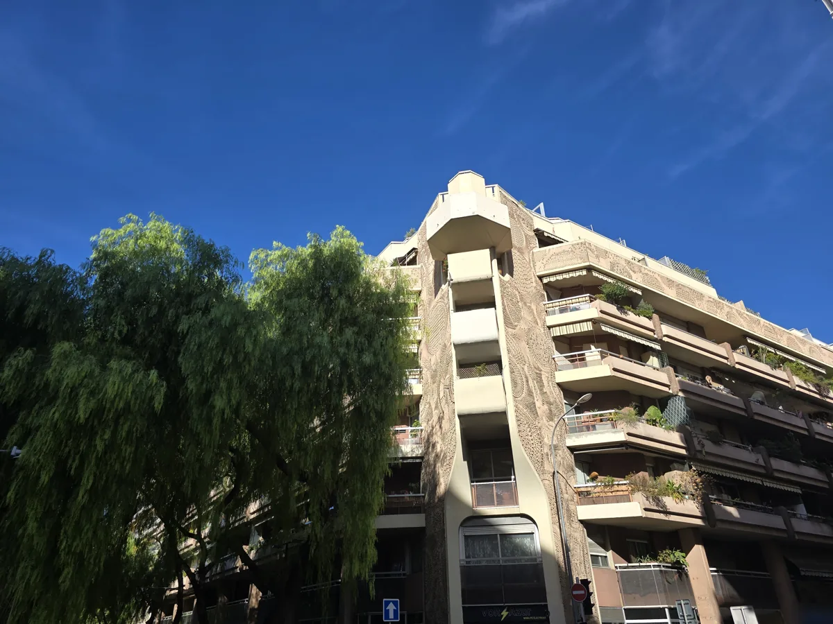 Façade d'angle de la résidence L'Hélianthe, rue Arson à Nice : motifs en relief et balcons arrondis