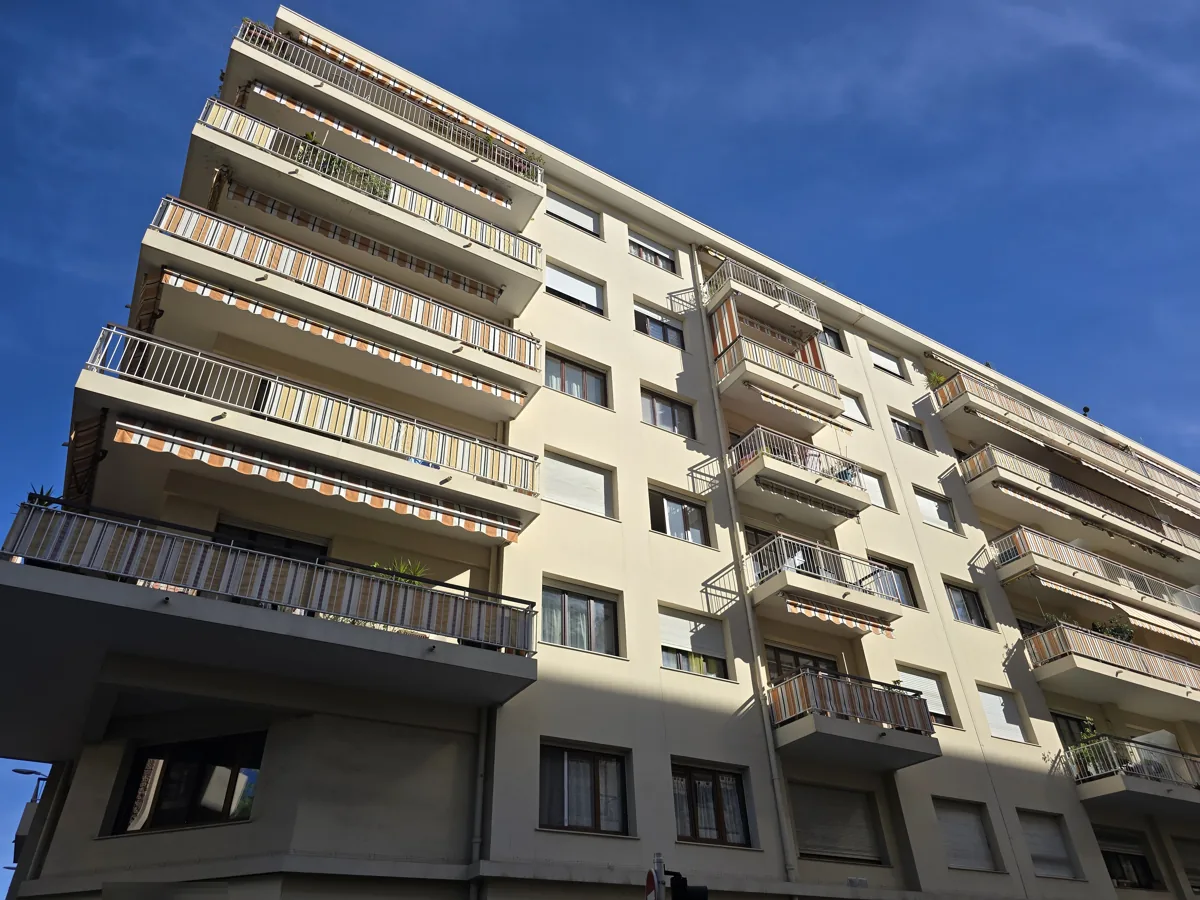 Façade de la résidence Le Rubens à Nice : balcons d'angle à stores rayés