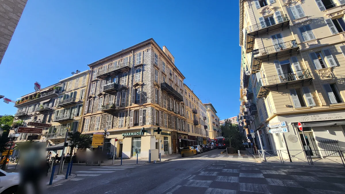 Carrefour de la rue Gioffredo côté Carabacel, près de la rue Defly à Nice : immeuble d'angle ancien à façade ouvragée et pharmacie