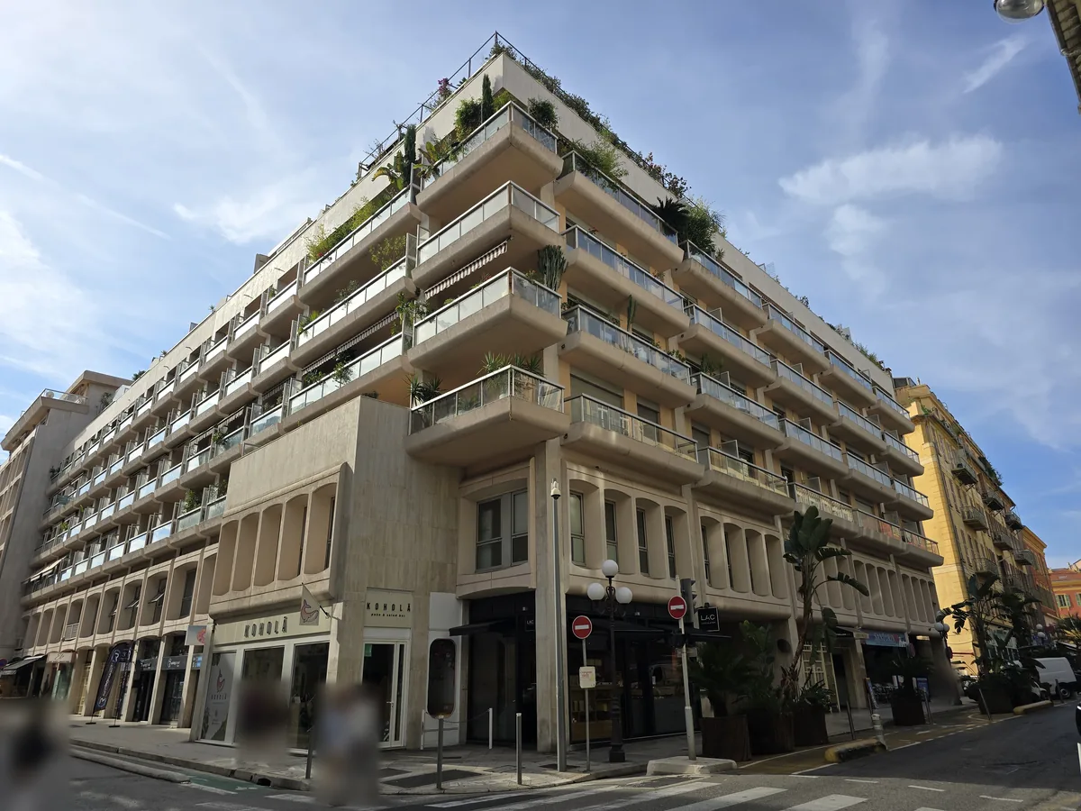 Résidence Le Pont Neuf à l'angle de la rue Chauvain et de la rue Gioffredo à Nice : terrasses filantes, derniers niveaux plantés et commerces en pied d'immeuble
