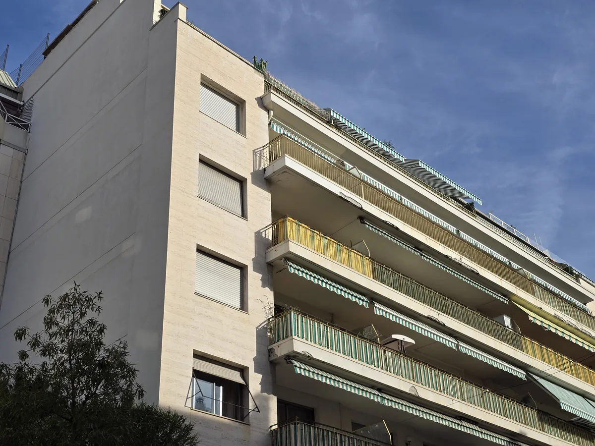 Résidence d'après-guerre à balcons filants et stores rayés verts, au 28 rue de l'Hôtel-des-Postes à Nice