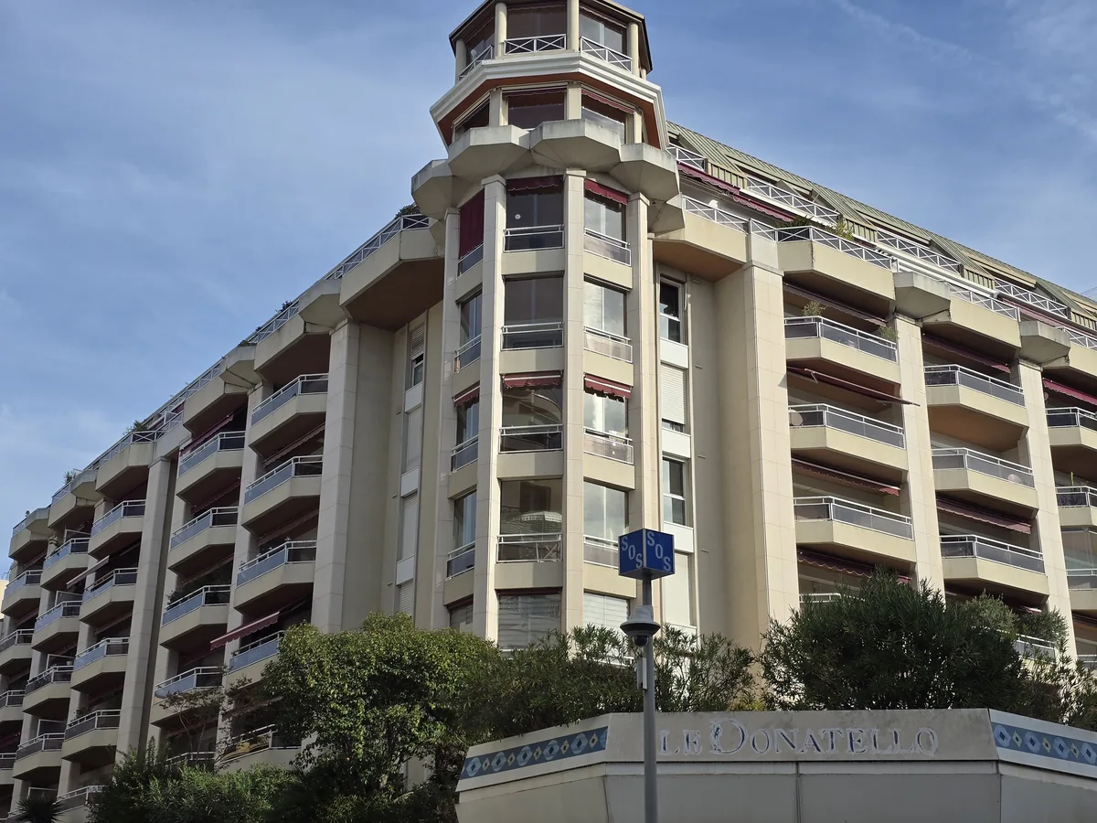 Résidence Le Donatello, 30 rue de l'Hôtel-des-Postes à Nice : tourelle d'angle, balcons en saillie et nom sur le soubassement