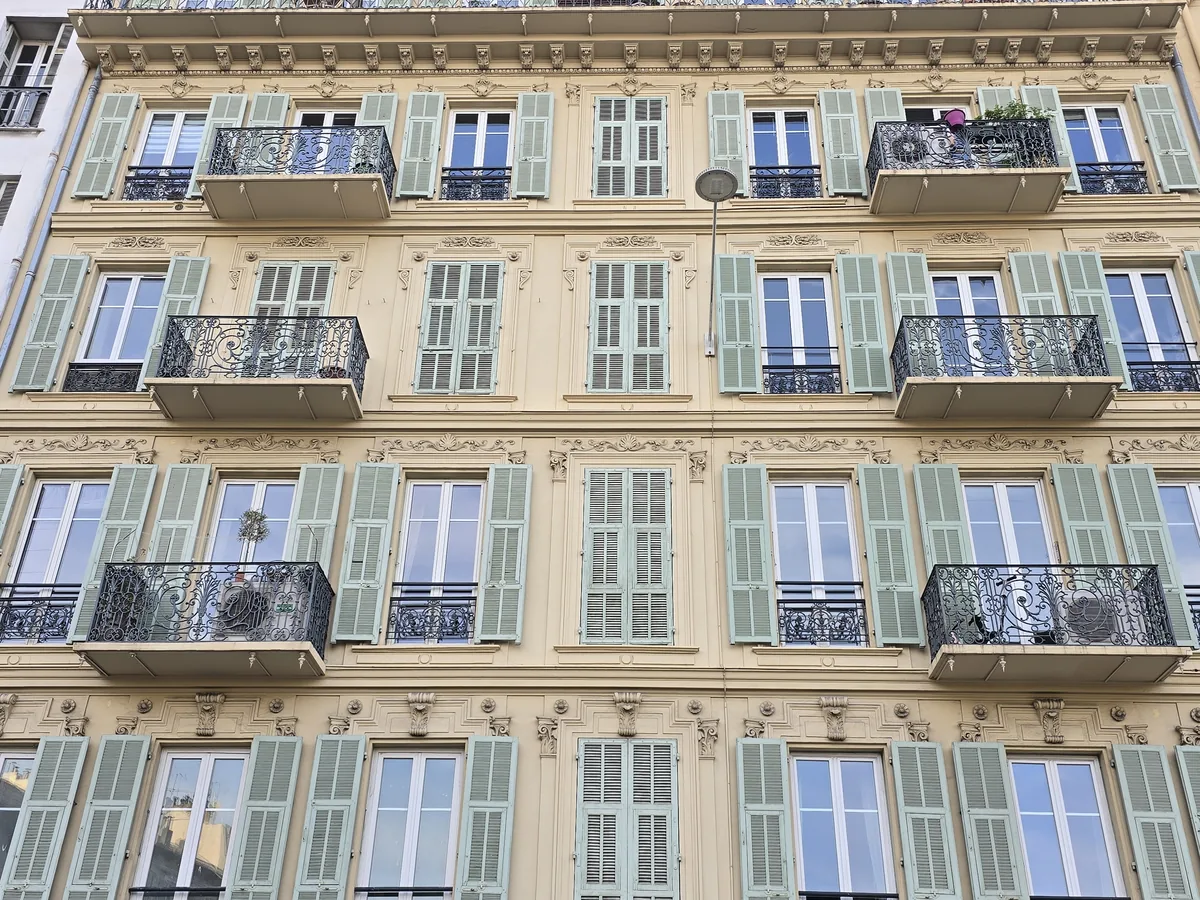 Façade Belle Époque du 17 rue Pastorelli à Nice : corniches, décors moulurés, volets persiennés vert clair et balcons en fer forgé