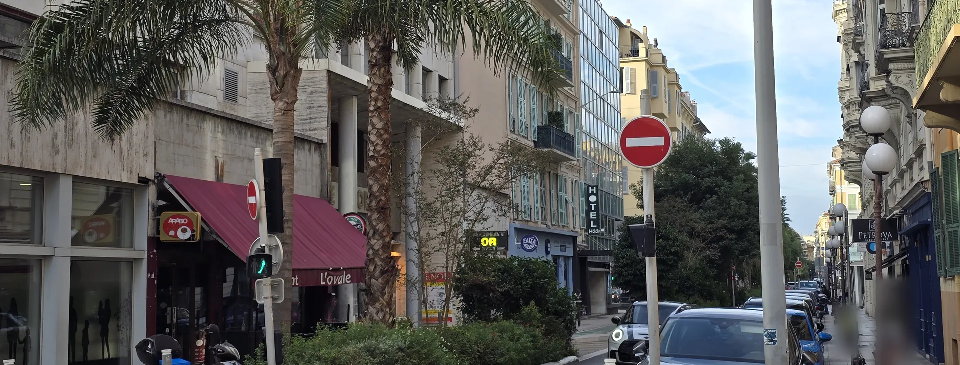 Rue Pastorelli à Nice vers l'avenue Jean-Médecin : palmiers, immeuble Nice-Europe des années 1960 et façades niçoises à balcons ouvragés